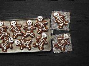 several decorated cookies in the shape of skeletons on a baking sheet with one cut out