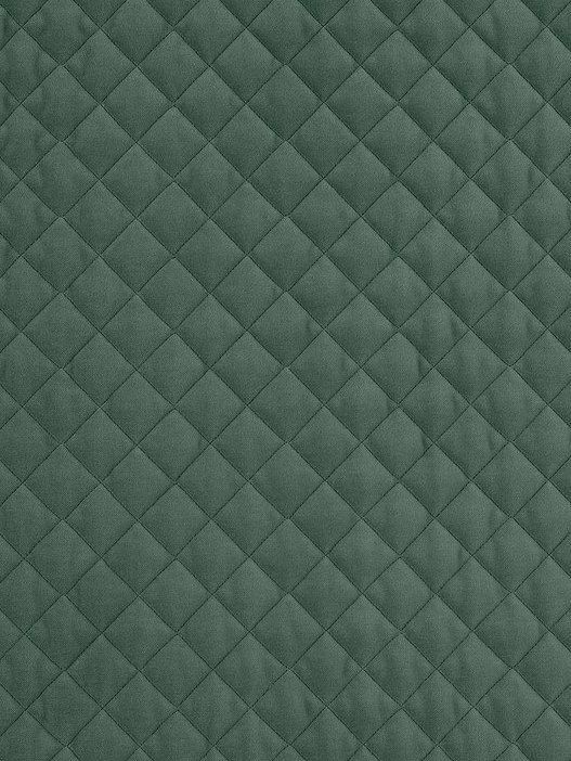 an upholstered green quilted fabric textured with small squares and rectangles