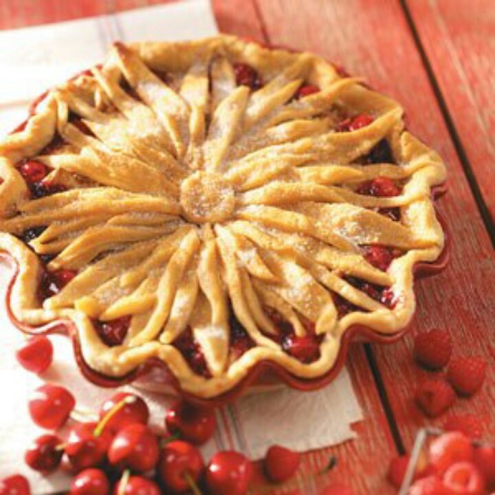 a cherry pie sitting on top of a wooden table