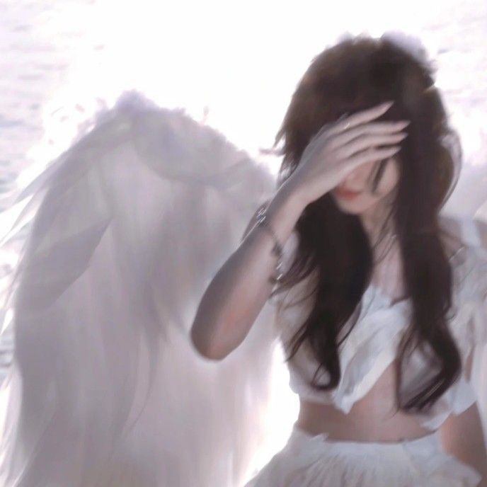 a woman with long hair and white wings on her head is sitting in front of an angel