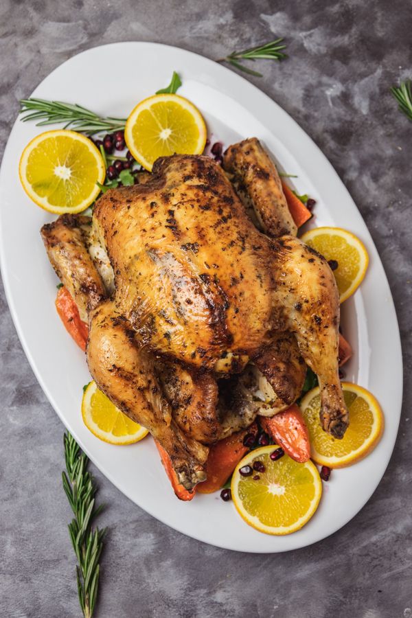 a white plate topped with chicken and lemons