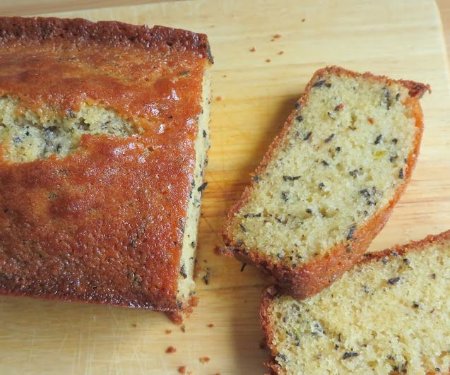 sliced loaf of bread sitting on top of a cutting board next to slices of cake