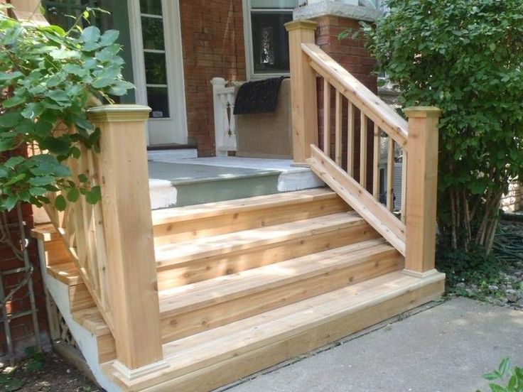 a wooden porch with steps leading up to the front door and an outside jacuzzi tub