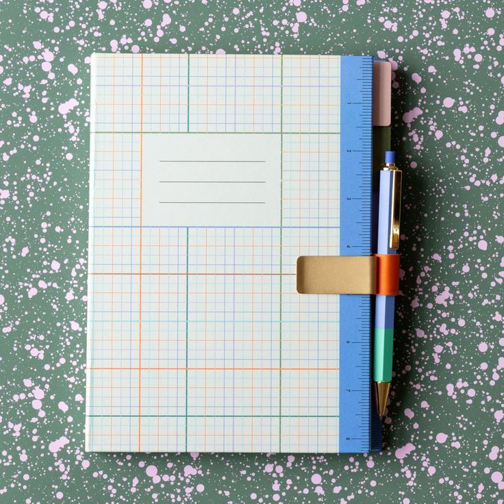 a notepad with a pen on top of it next to a ruler and pencil