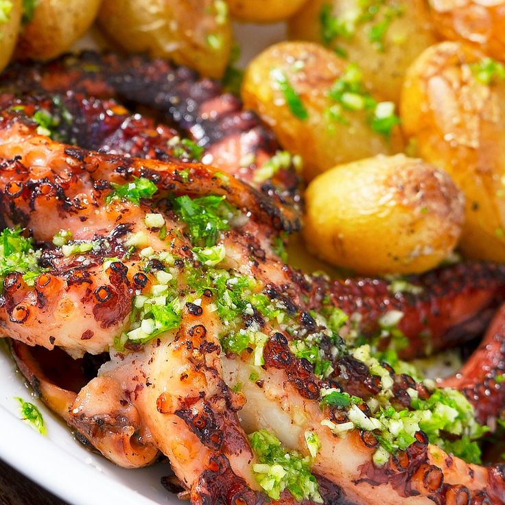 a plate with chicken, potatoes and broccoli covered in seasoning on it