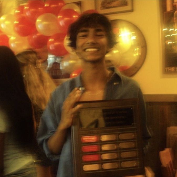 a man holding up an electronic device in front of his face at a birthday party