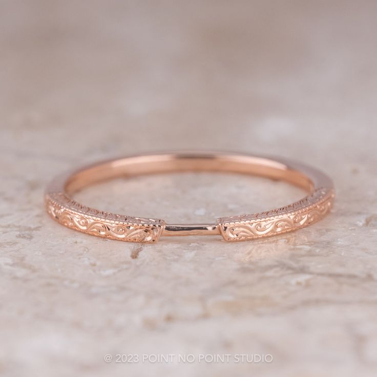 a rose gold wedding band on a marble surface