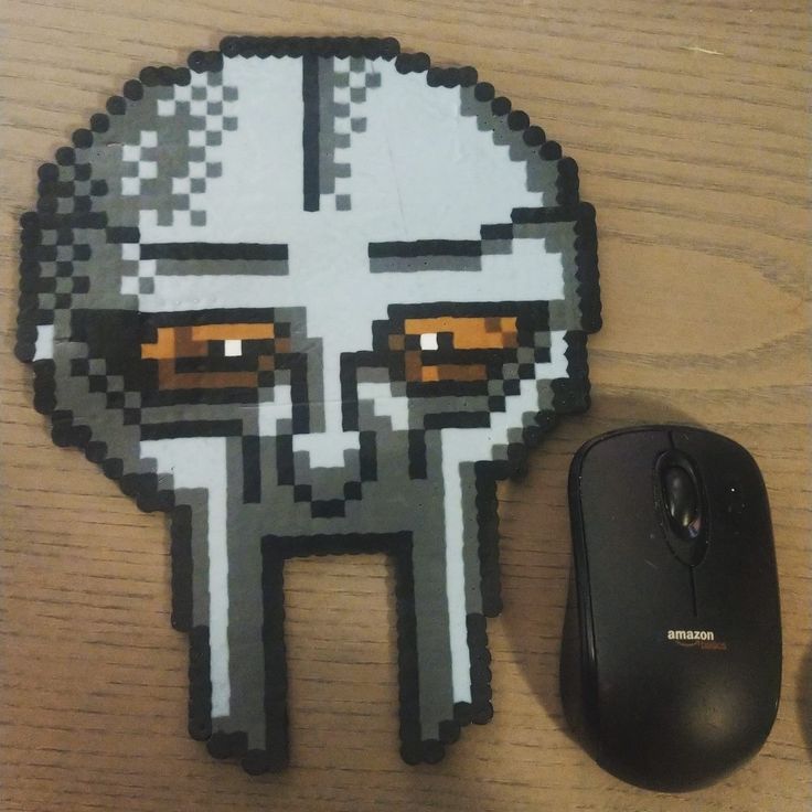 a computer mouse sitting next to a sticker with an image of a face on it