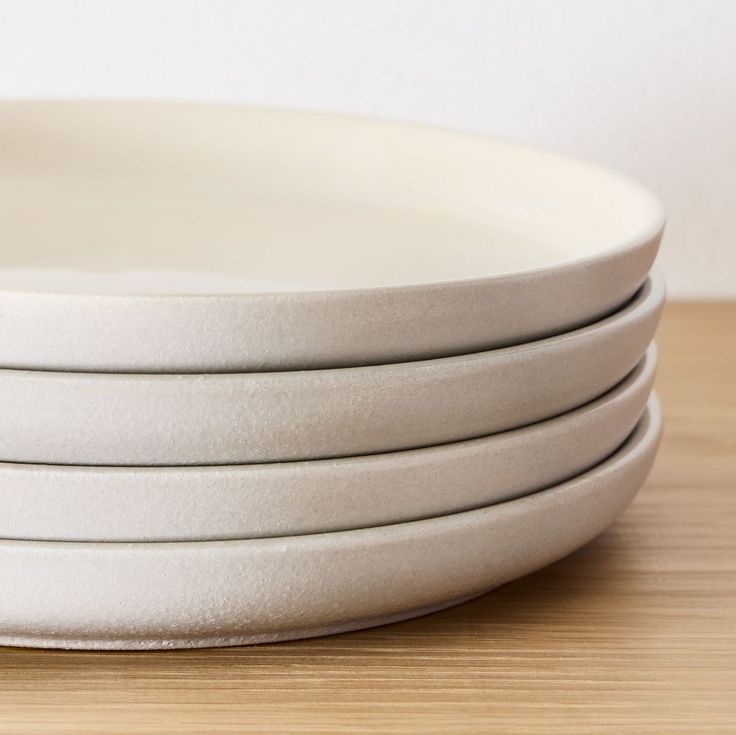 four white plates stacked on top of each other