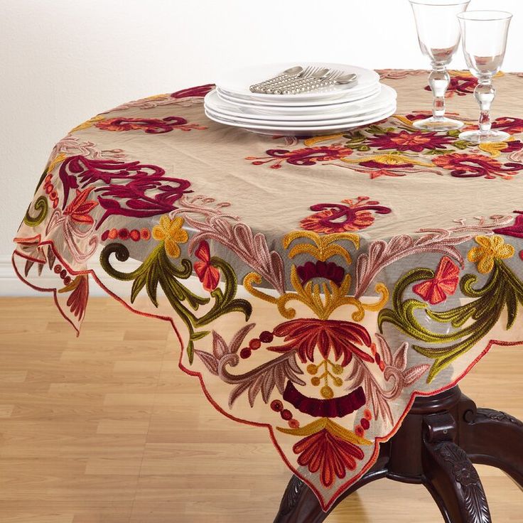 the table is covered with an elegantly designed cloth and has wine glasses on it