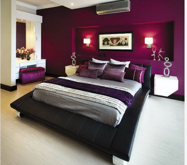 a bedroom with purple and white decor in the corner, along with a large bed