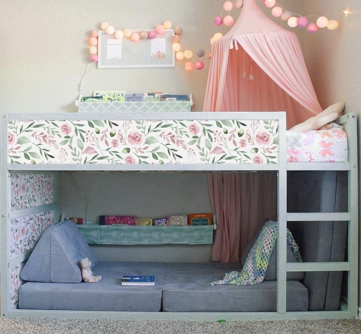 a child's bedroom with a bunk bed and pink curtains on the window sill