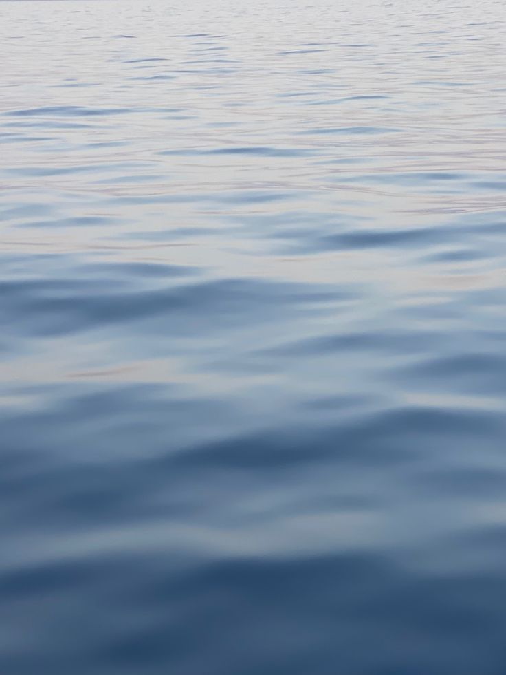 the water is very calm and blue with no one on it or any other boat