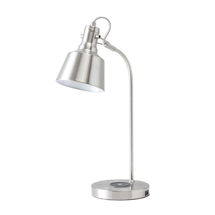 a silver desk lamp on a white background with clippings to the side and one light turned on