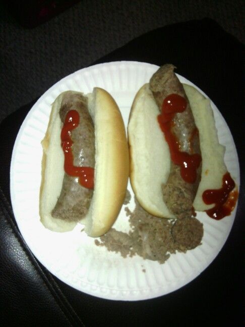 two hot dogs with ketchup and mustard on a paper plate