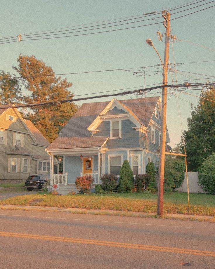 a blue house sitting on the side of a road