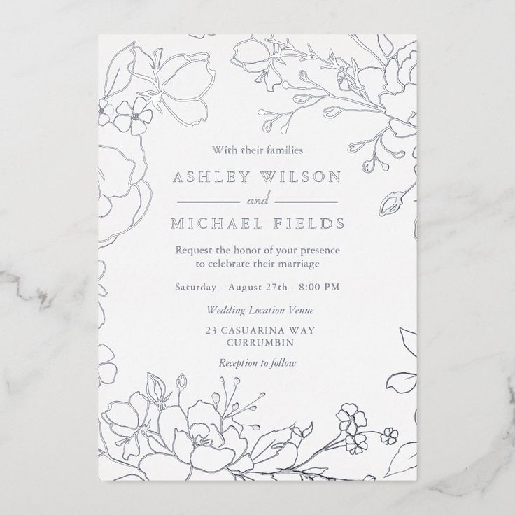 a wedding card with flowers and leaves on the front, in grey ink against a white marble background