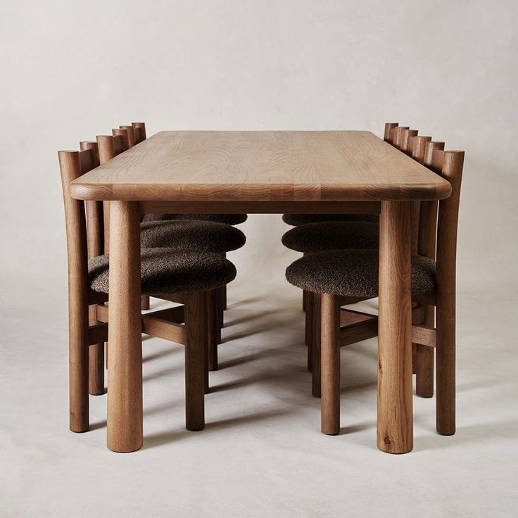 a wooden table with four chairs sitting at it's base and one chair on the other side