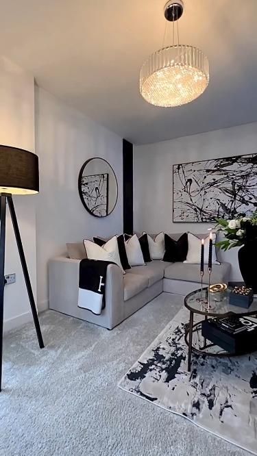 a living room filled with furniture and a chandelier hanging from the ceiling above it