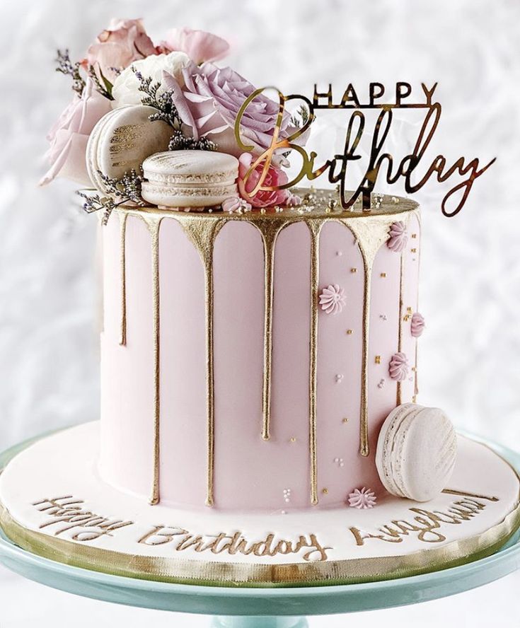 a pink and gold birthday cake with the words happy birthday on it's top