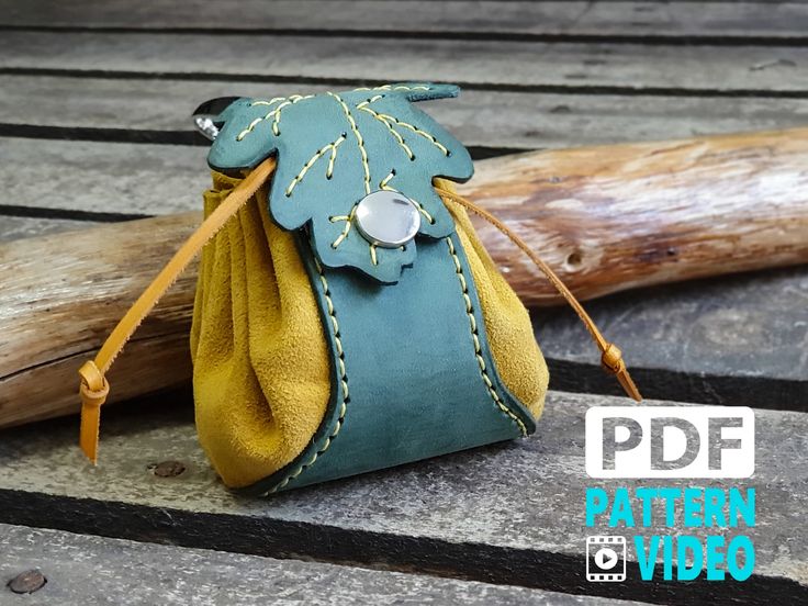 a small purse sitting on top of a wooden table next to a piece of wood