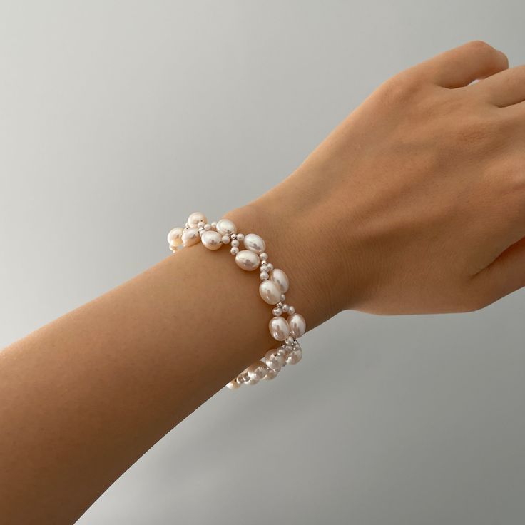 The Handmade Twist Oval Pearls Bracelet is a unique and stunning piece of jewelry that matches well with any bridal dress or other daily outfit. Made by skilled artisans, this bracelet features a twist design that adds a touch of elegance to the smooth and lustrous oval-shaped pearls. The pearls are hand-selected for their quality and color, ensuring that each bracelet is one-of-a-kind. Pearl Type: Freshwater Pearls Pearl Quality: [Shape]: Oval Shape [Pearl Size]: 6-7mm [Blemish]: Minor [Luster] Delicate Pearl Bracelets For Formal Occasions, Elegant Crystal Bangle Bracelet, Elegant Pearl White Bracelets For Weddings, Pearl White Oyster Bracelet Jewelry, Elegant Crystal Bracelet With Round Beads And Jubilee Style, Formal Delicate Pearl Bracelets, Elegant Pearl White Wedding Bracelet, Elegant Pearl Bracelet For Wedding, Elegant Oval Bracelets For Party