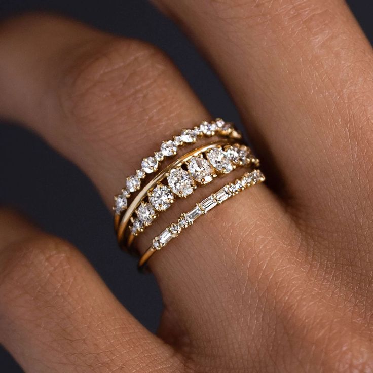 a woman's hand with three different rings on her finger and the ring is made out of gold