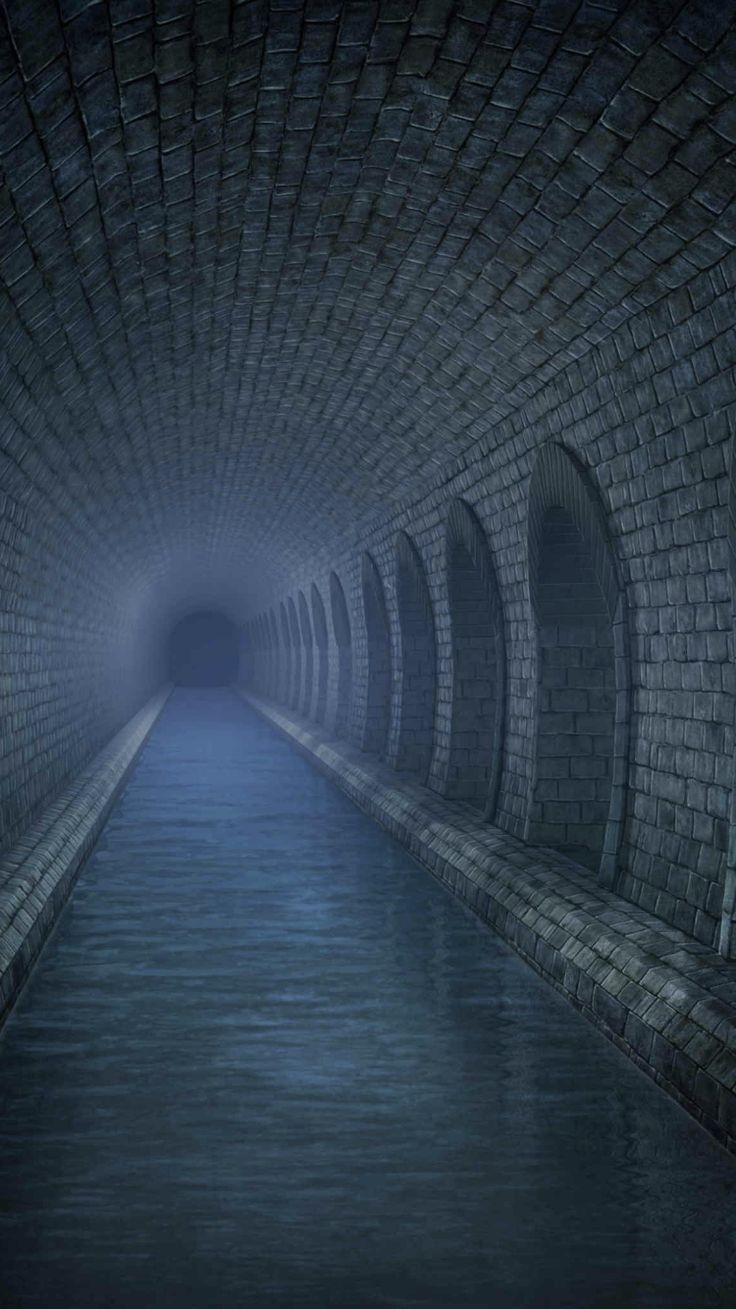 a dark tunnel with water in it and light coming from the end at the end