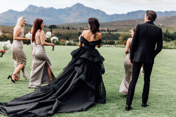 a group of people standing on top of a lush green field next to each other