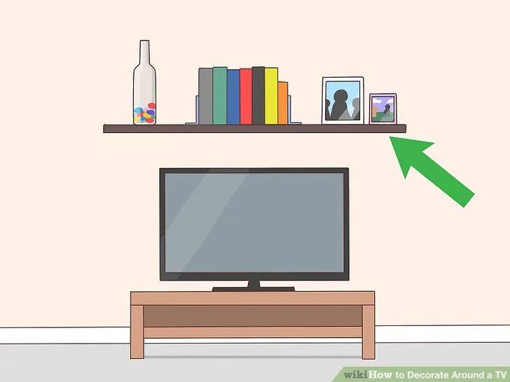 a flat screen tv sitting on top of a wooden table next to a book shelf