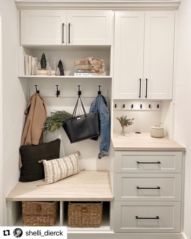 a white closet filled with lots of drawers and hanging items on the wall next to a sink