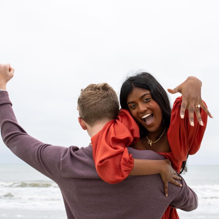 a woman holding a boy in her arms on the beach