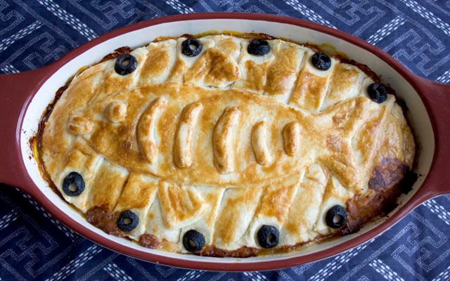 a baked dish with blueberries and bananas in it on top of a tablecloth