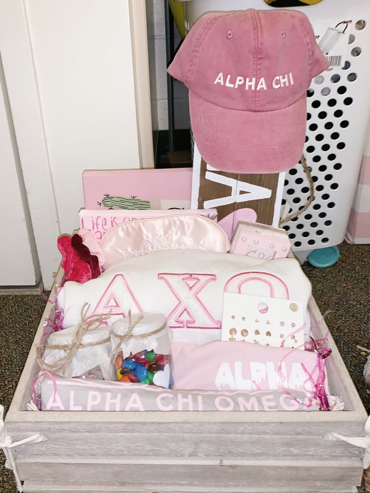 a pink hat sits on top of a white box filled with personalized items and gifts