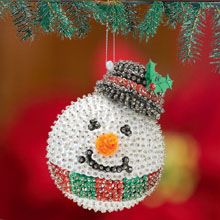 a beaded ornament hanging from a christmas tree in the shape of a snowman