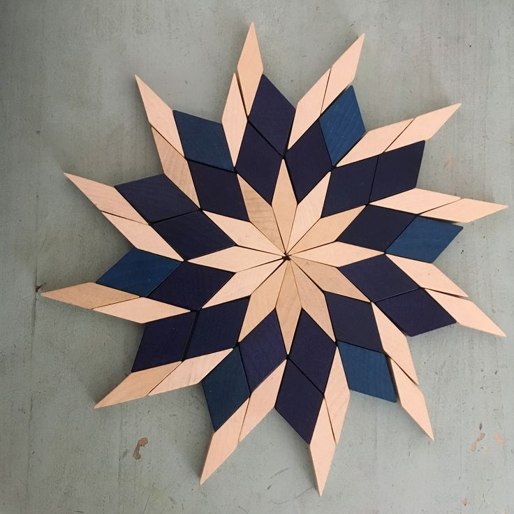 a blue and pink star shaped object sitting on top of a cement floor next to a wall