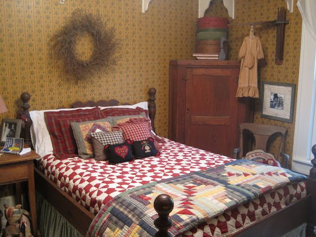 a bed room with a neatly made bed next to a wooden dresser and window sill