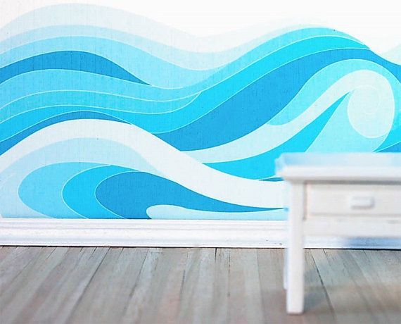 a white table sitting in front of a wall with blue waves painted on it's side