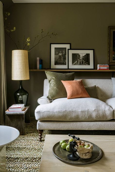 a living room with a white couch and coffee table in front of a painting on the wall