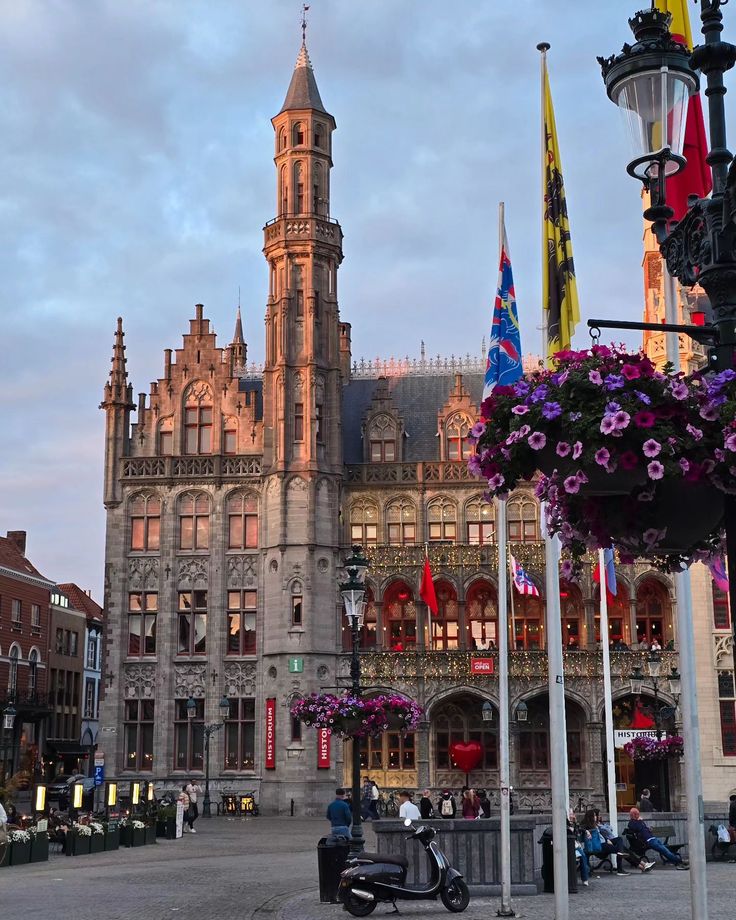 an old building with many flags and flowers