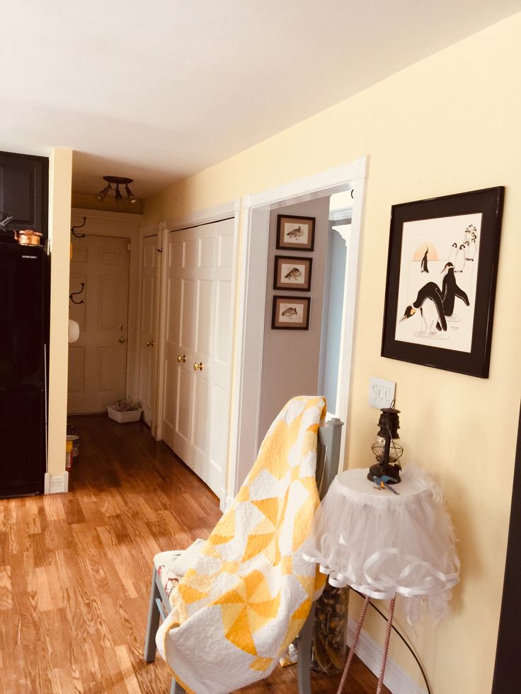 a living room with hard wood floors and yellow walls