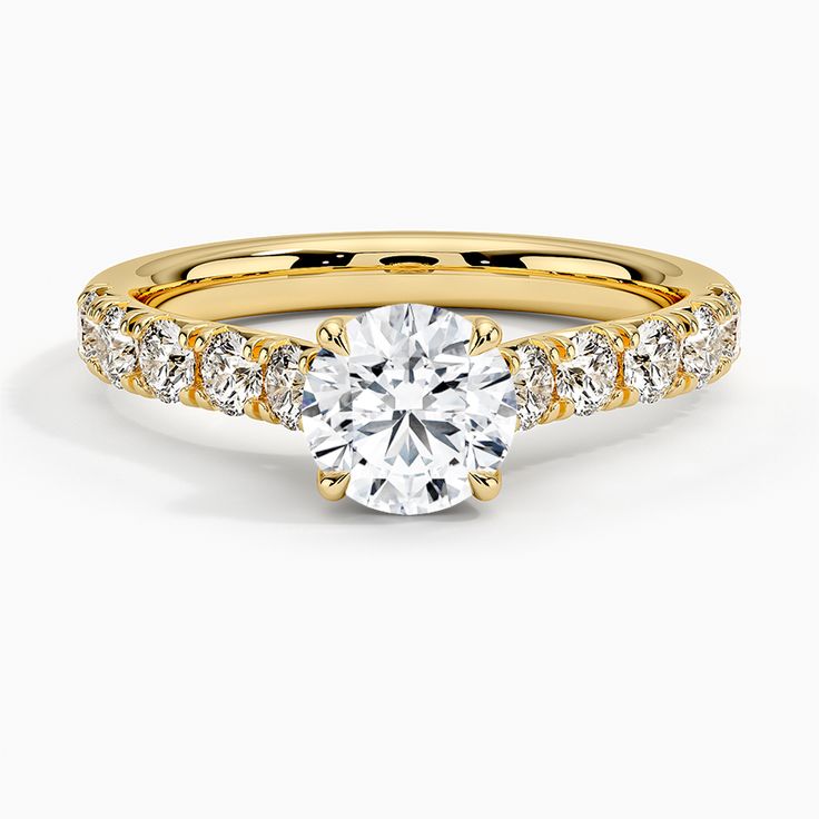 a rose gold engagement ring with diamonds on the band and a round cut diamond in the center