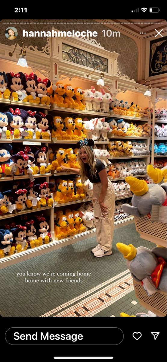 a woman standing in front of a store filled with stuffed animals