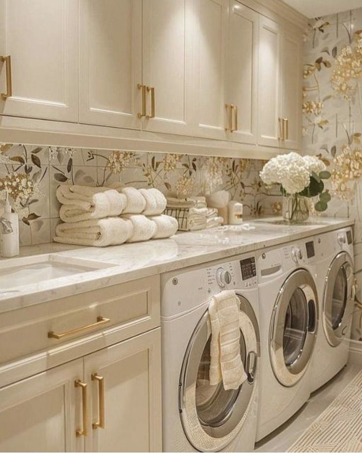 a washer and dryer in a room with flowers on the counter top next to each other