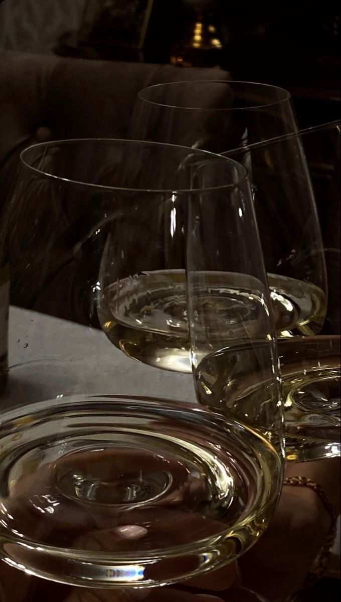 three wine glasses sitting on top of a table