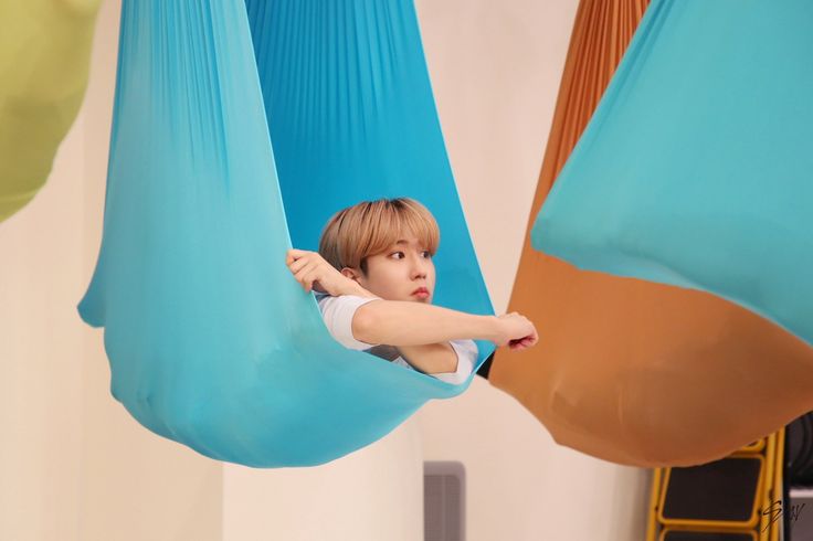 a young boy is sitting in a hammock