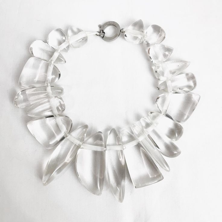 The necklace is made of irregular-shaped clear resin beads giving the illusion of icicles—a spectacular piece to wear day or night.  The necklace is 16 inches long and weighs 9 ounces.  The necklace is a modern look that will never go out of style. Modern White Crystal Jewelry, Elegant Plastic Jewelry For Parties, Elegant Resin Necklaces For Party, Clear Lucite Party Jewelry, Trendy Clear Resin Jewelry, Silver Plastic Jewelry For Party, Chic Resin Jewelry For Party, Clear Glass Drop Jewelry, Clear Drop-shaped Glass Jewelry