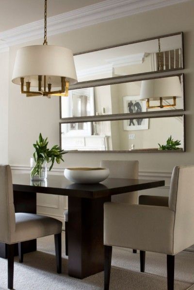 a dining room table with chairs and a mirror