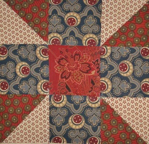 a patchwork quilt with red, blue and green designs on it's center