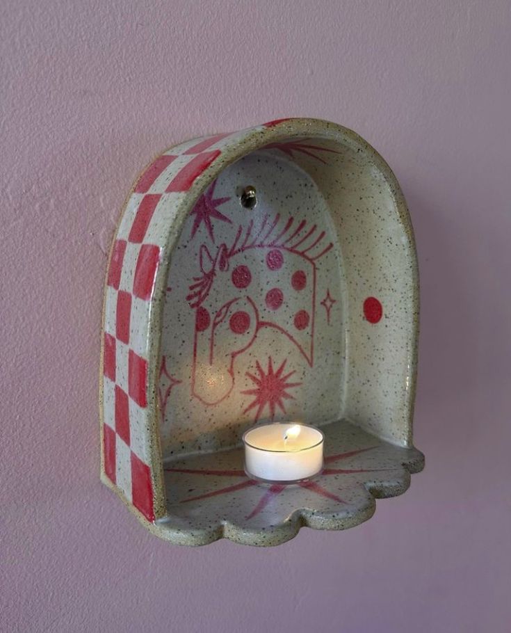 a candle is lit in a ceramic holder